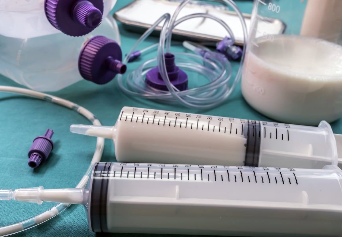 A plastic syringe filled with liquid formula.